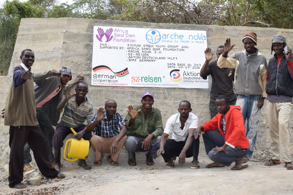 Männergruppe vor Sanddamm in Kenia