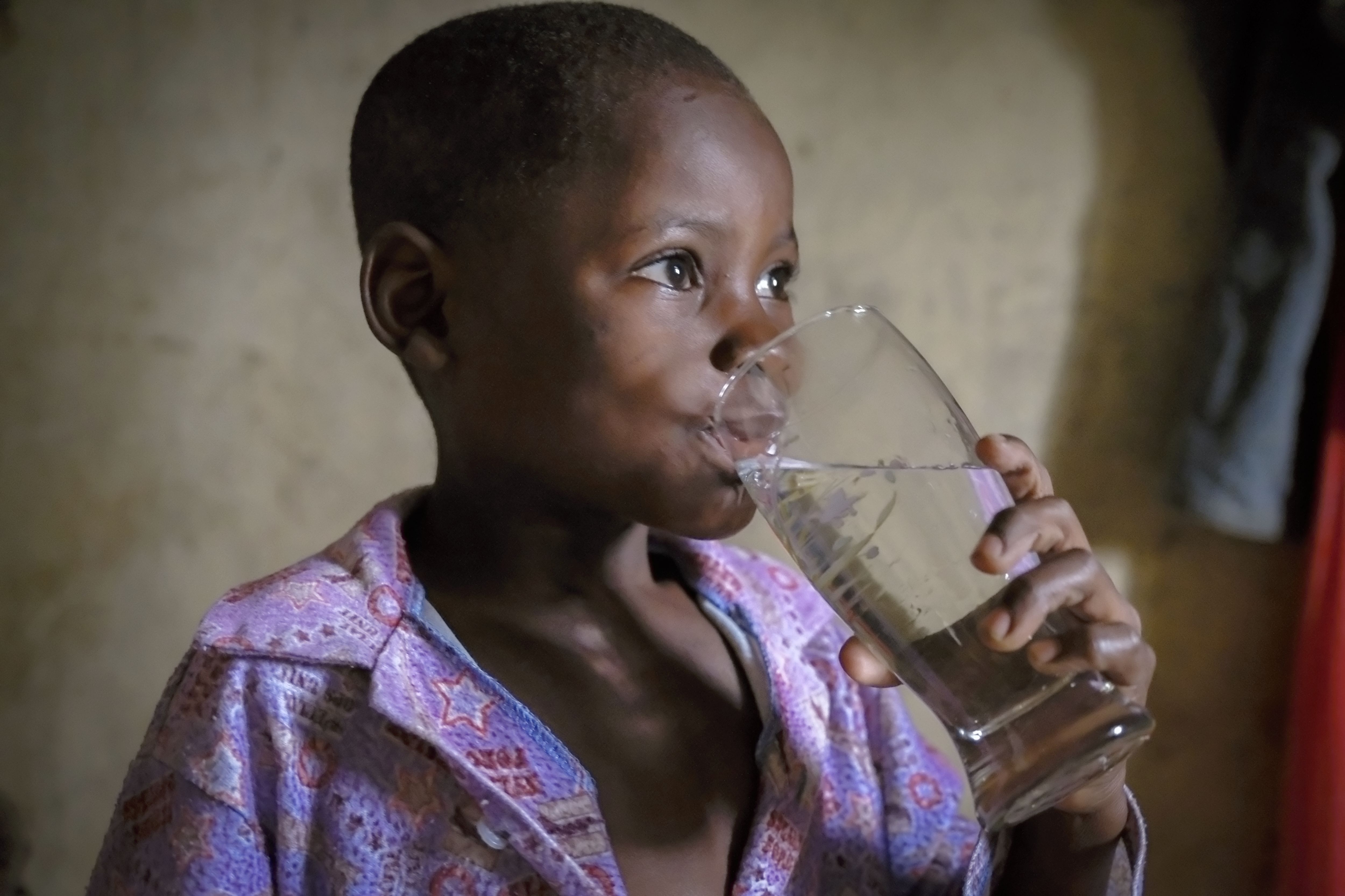 Evans Kawumbu trinkt ein Glas Wasser