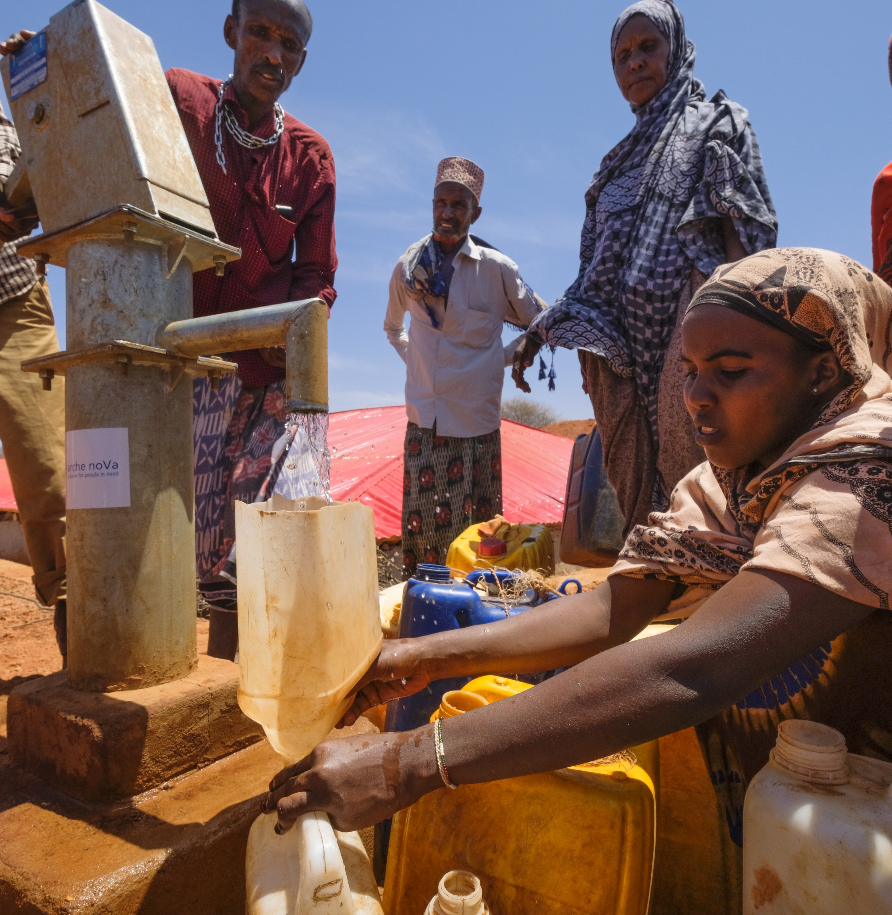 Frau füll Kanister mit Wasser aus einem Brunnen in Mali.