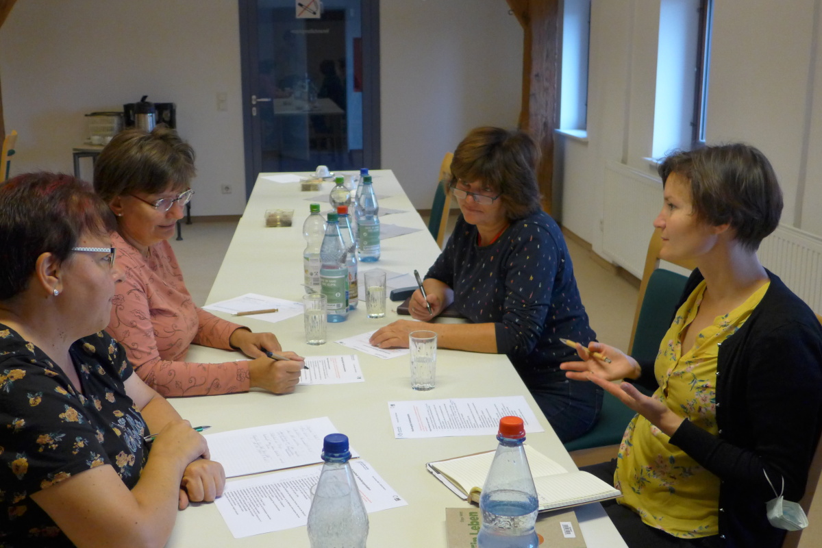 Vier Frauen an einem Tisch im Gespräch vertieft