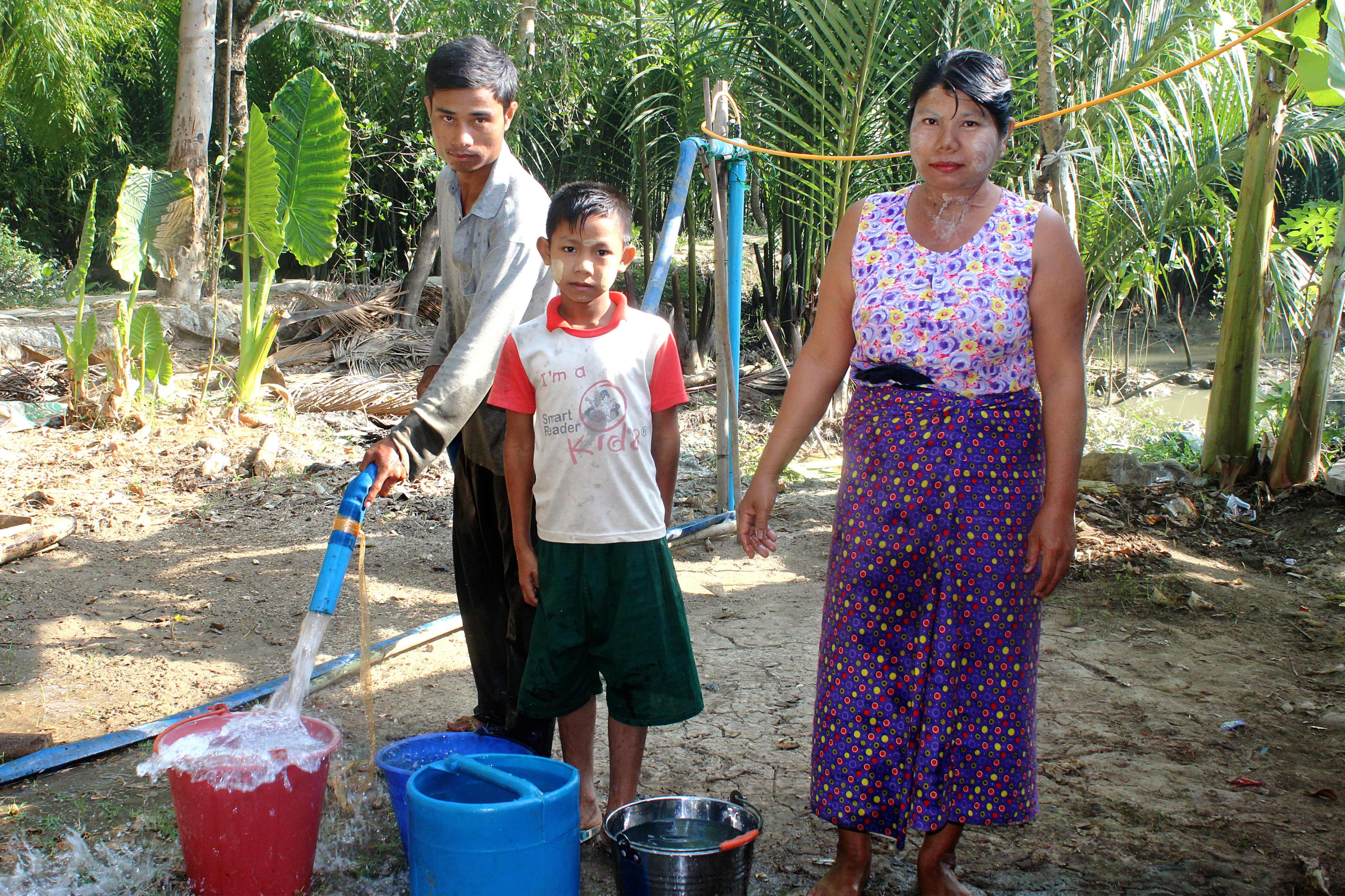 Familie füllt Eimer mit Wasser
