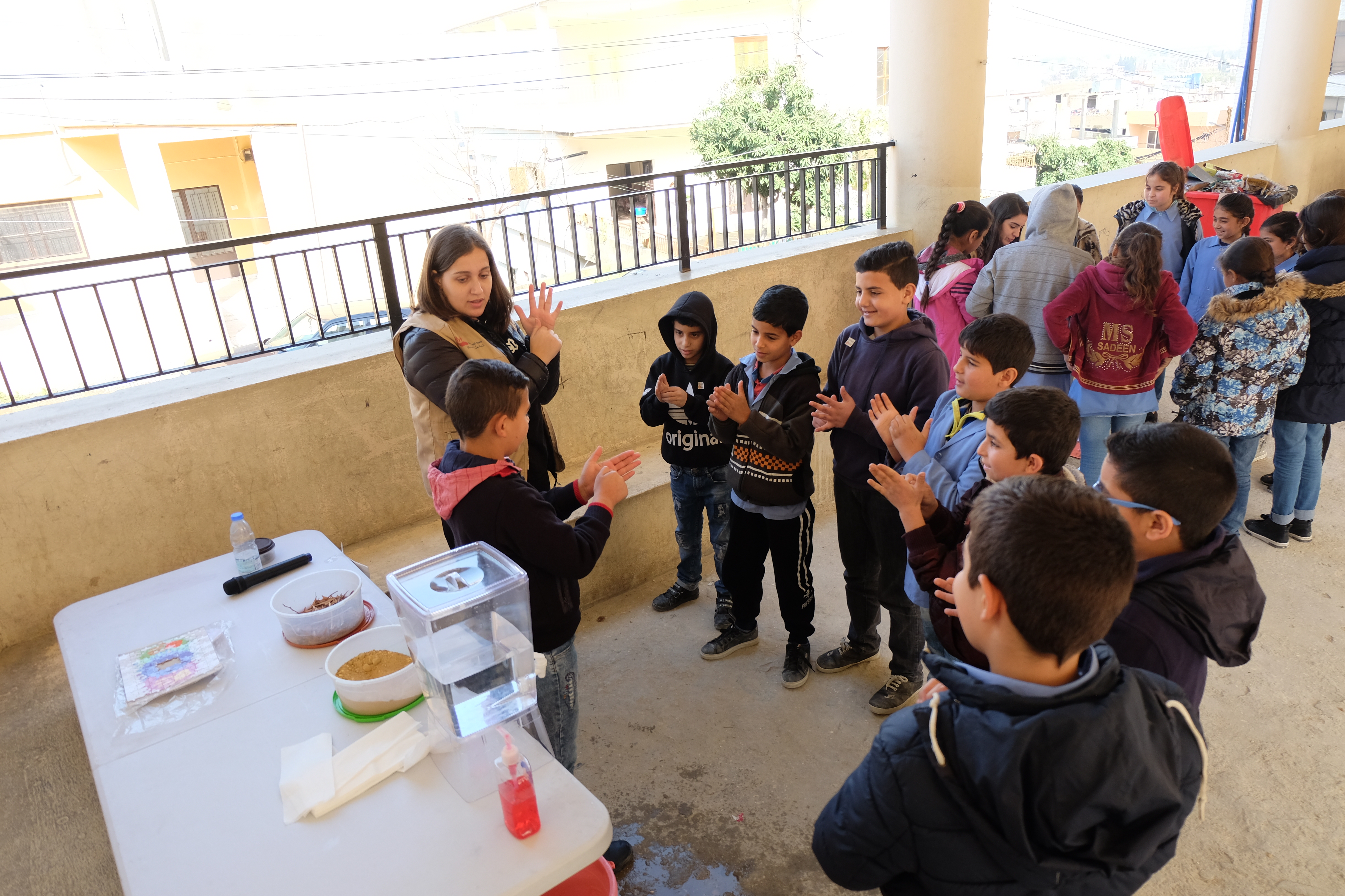 Blick auf Gruppe von Kindern und eine erwachsene Person, die richtiges Händewaschen trocken üben