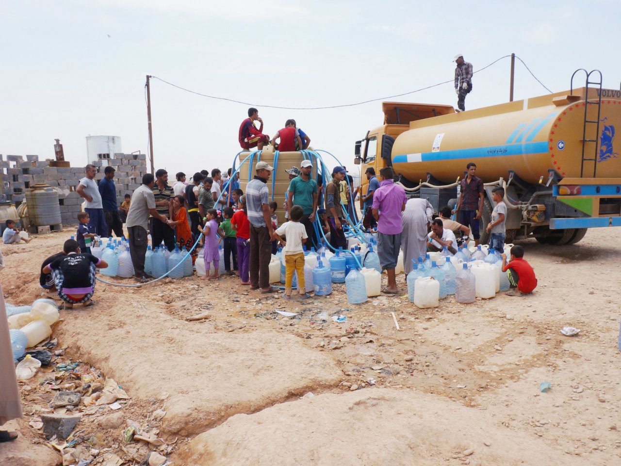 Flüchtlinge erhalten Trinkwasser durch mobile Tanklastwagen