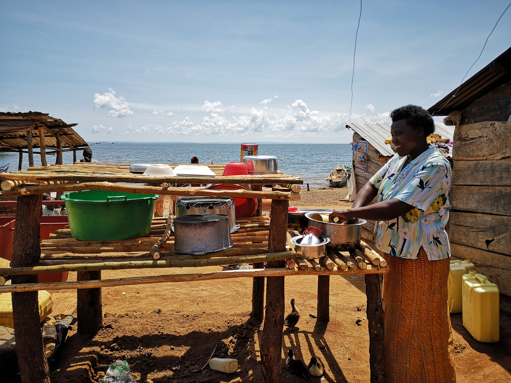 Frau wäscht Geschirr in Nangoma, Uganda.