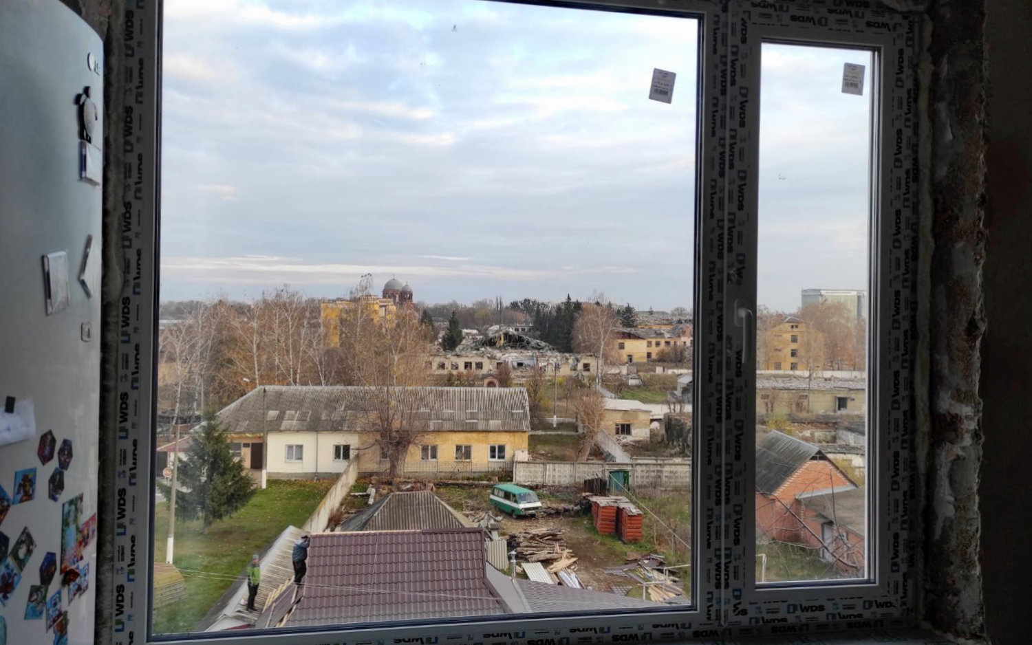 Blick aus einem Haus auf das vom Krieg zerstörte Okhtyrka, in dem arche noVa die Fenster repariert hat