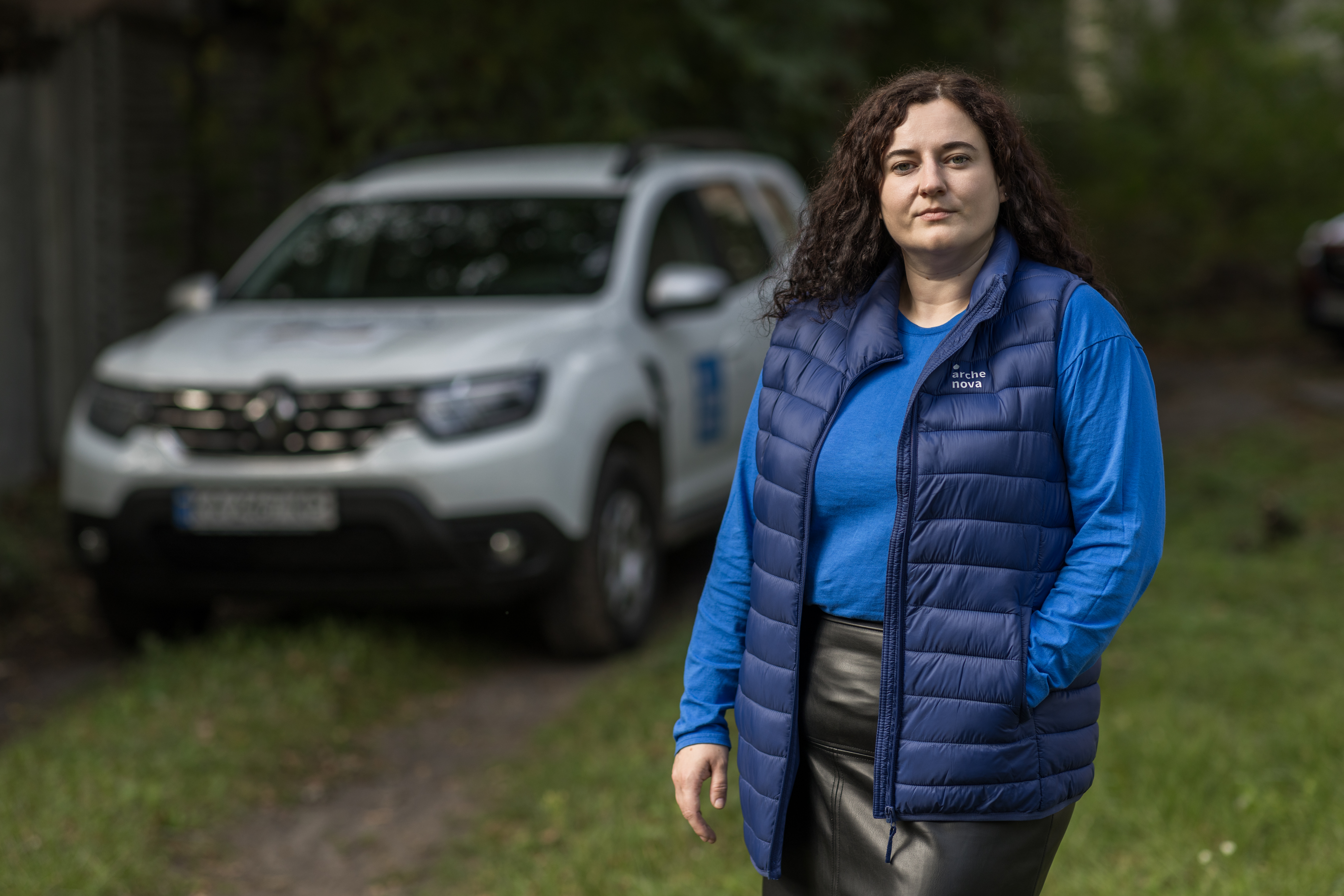 Darya Romanenko, Landesleiterin Ukraine, im Hintergrund ist unscharf ein weißer Pkw zu sehen.