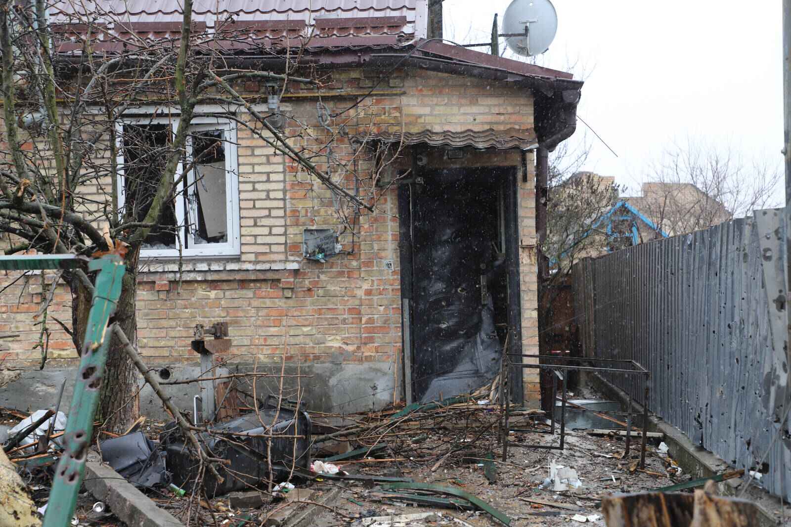 Eine im Krieg zerstörte Eingangstür eines Hauses, weitere zerstörte Gegenstände
