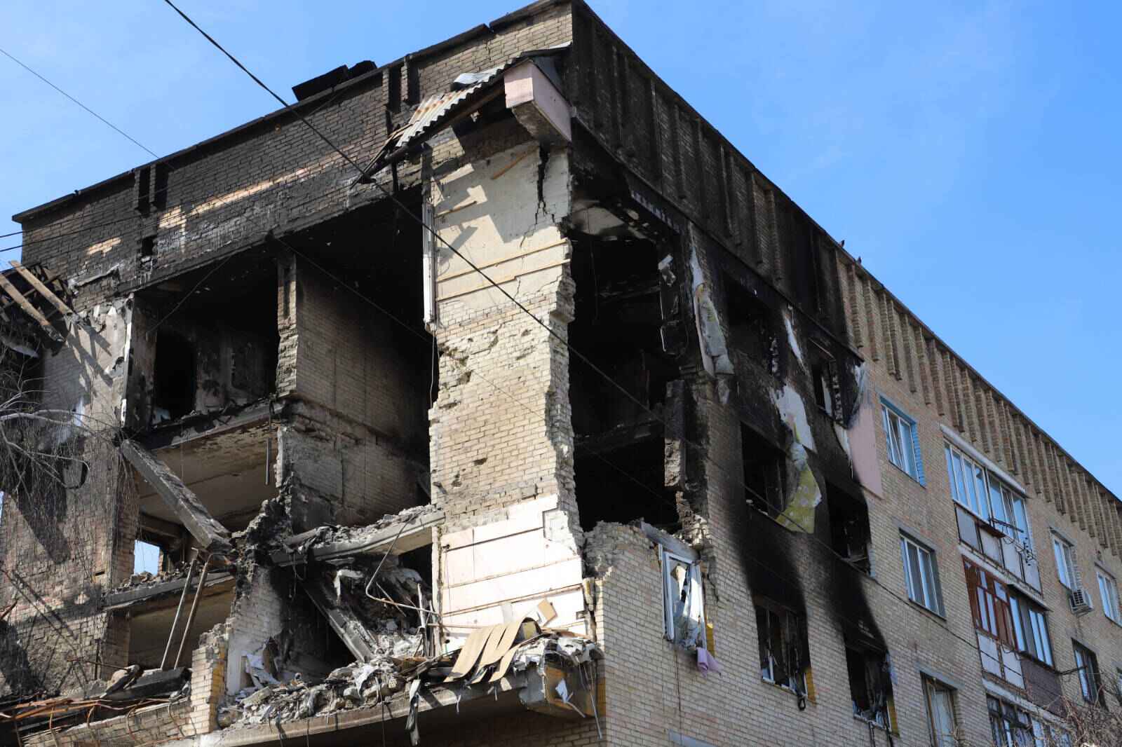 Several exterior walls are missing from a corner house