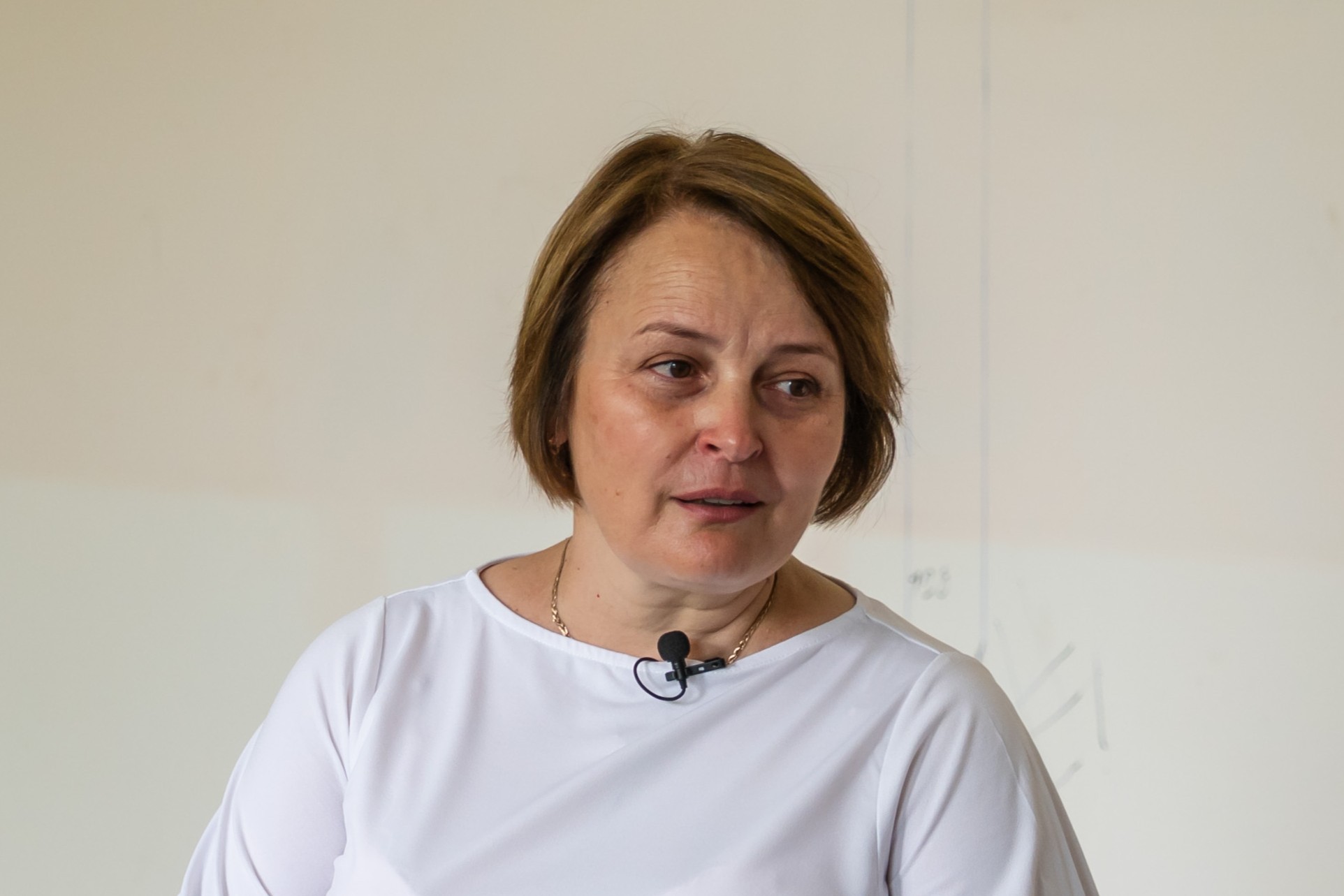 Das Foto zeigt eine Frau mittleren Alters mit kinnlagem hellbraunen Haar und einem weißen Shirt.