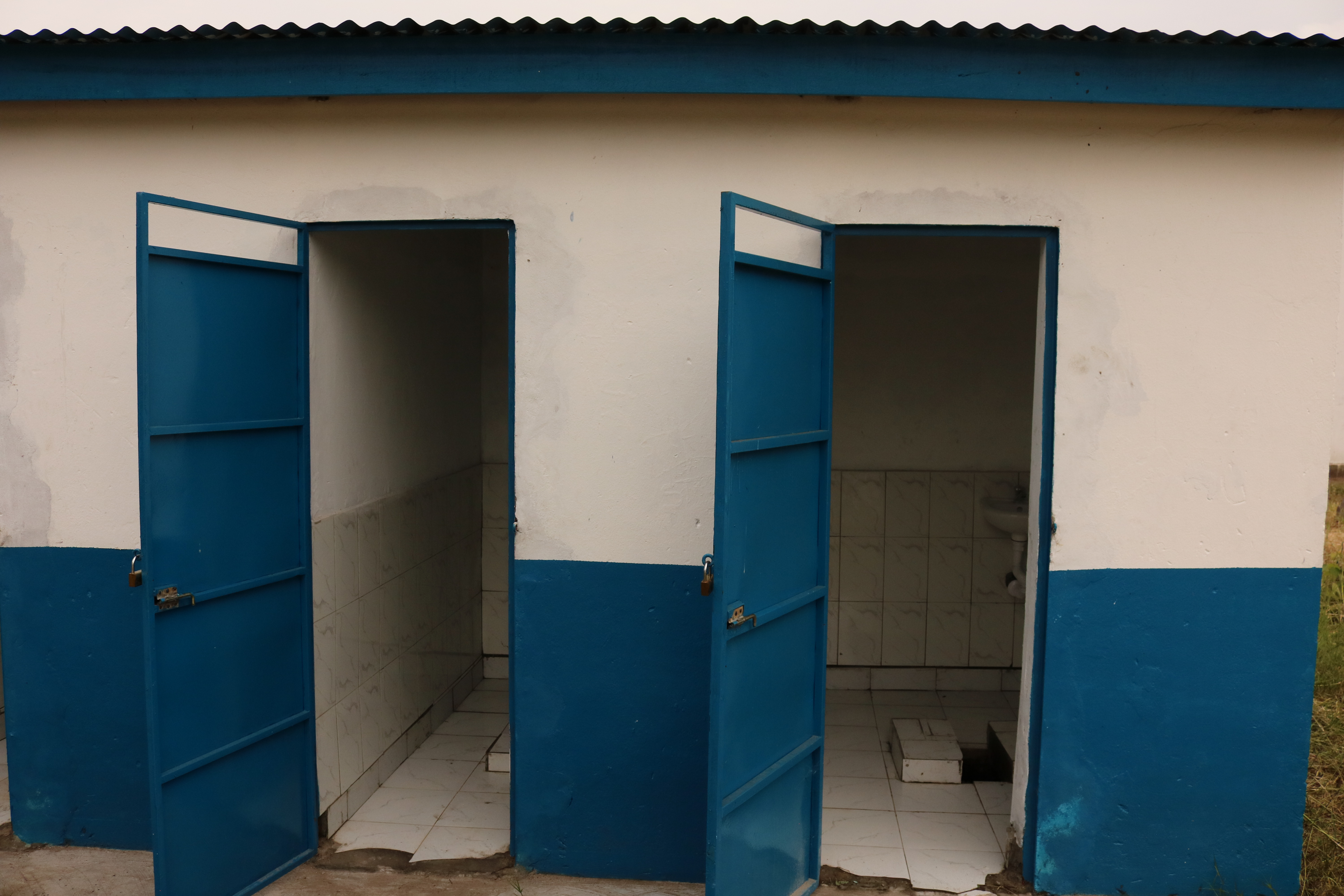 ein saniertes kleines Toilettenhaus mit zwei weit offen stehenden Klotüren
