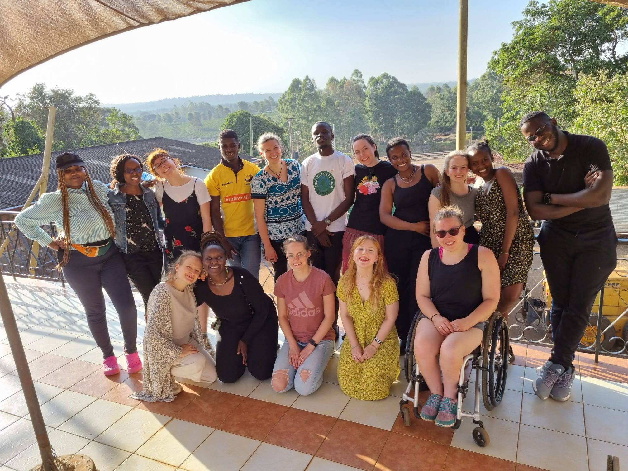 Das Bild zeigt ein Gruppenfoto der Teilnehmenden des kenianisch-deutschen Austauschsprogramms. Im Hintergrund ist Waldlandschaft zu sehen.