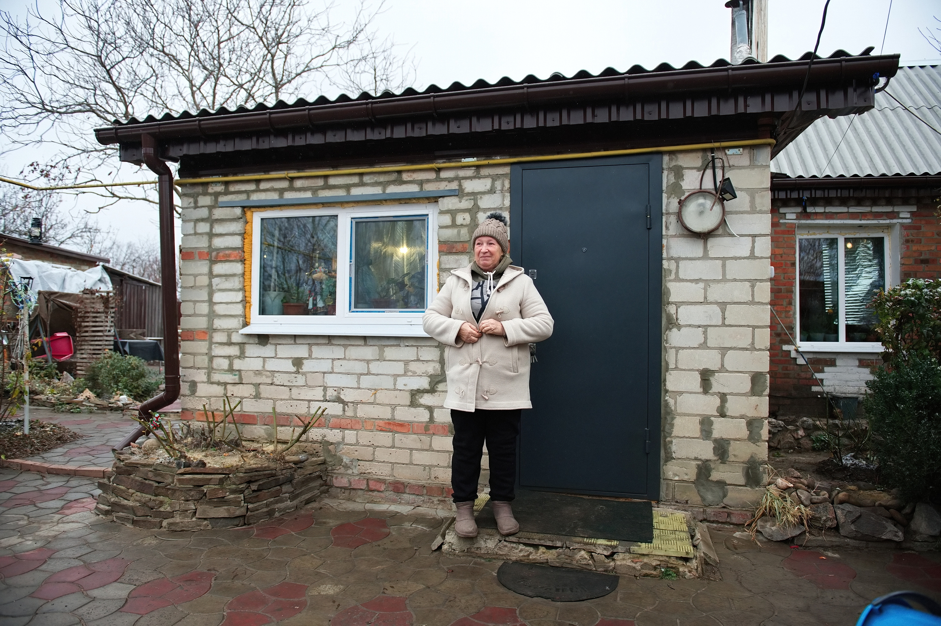 Das Bild zeigt Lyubov Demeshko vor ihrem Haus stehend