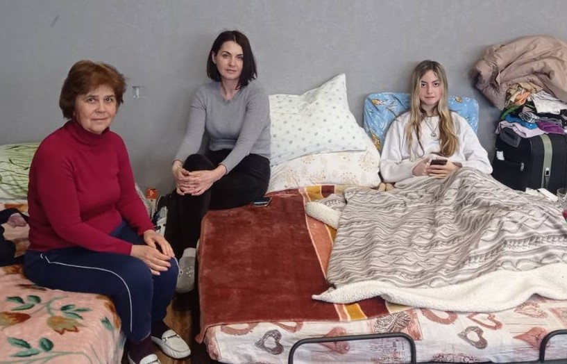 Portrait von drei Frauen auf Matratzen und Decken sitzend