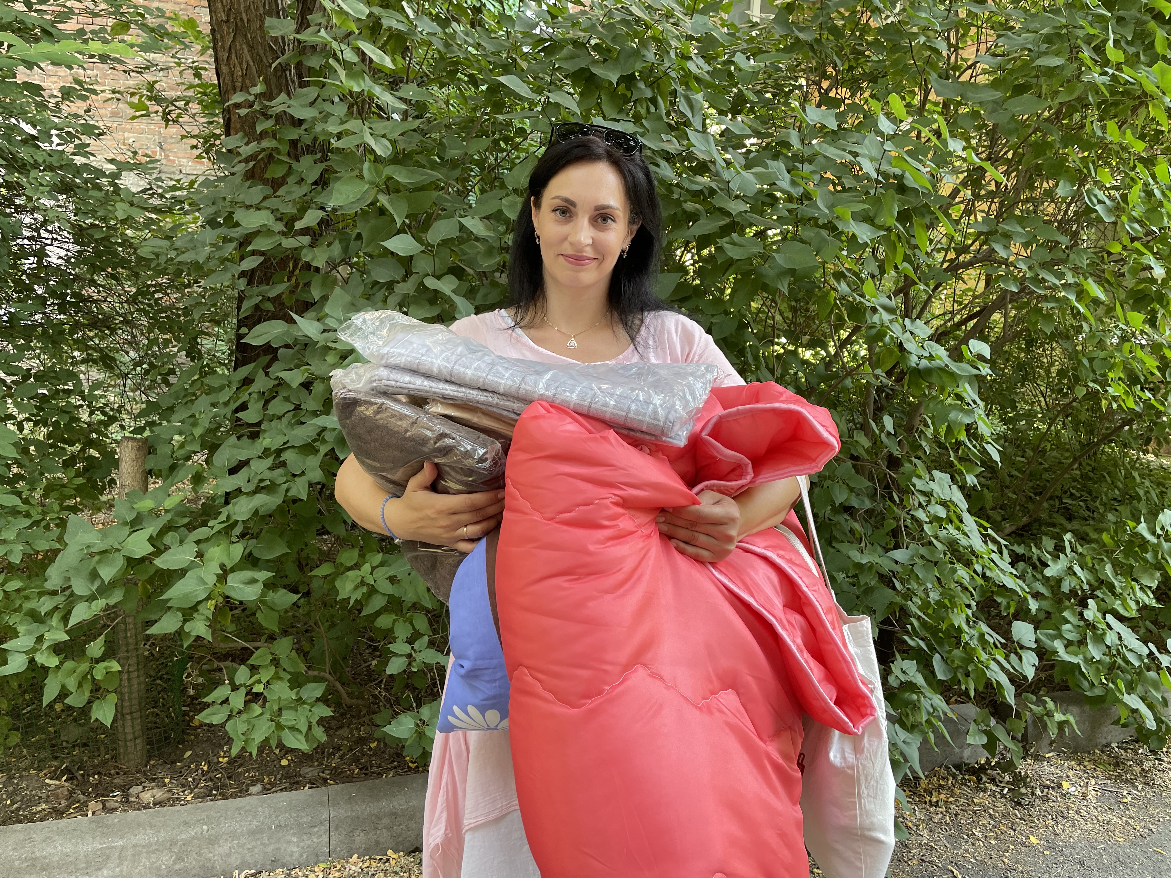 Frau erhält Decken und Bettwäsche in Dnipro