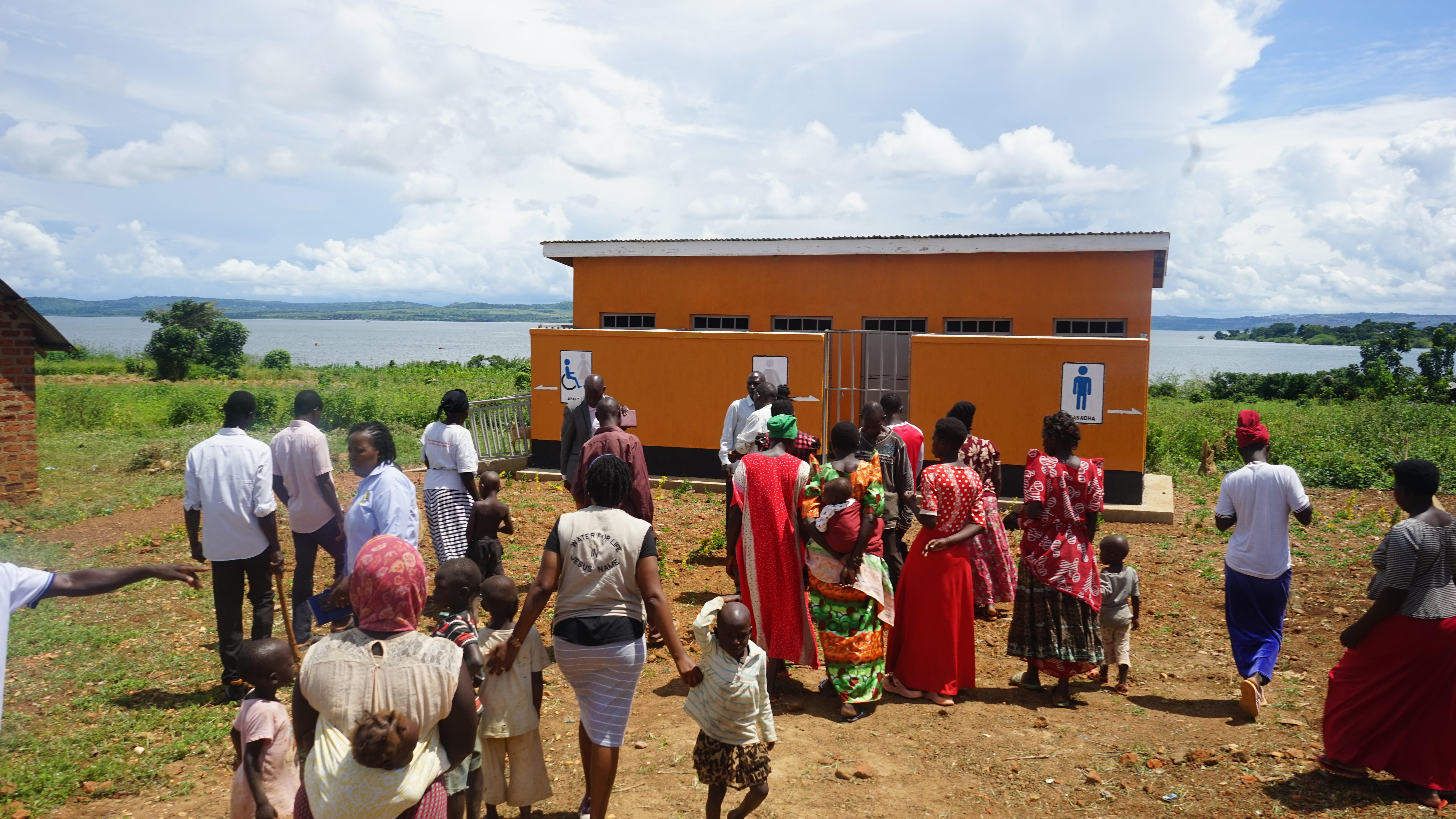 Menschengruppe läuft in Richtung eines Sanitärgebäudes
