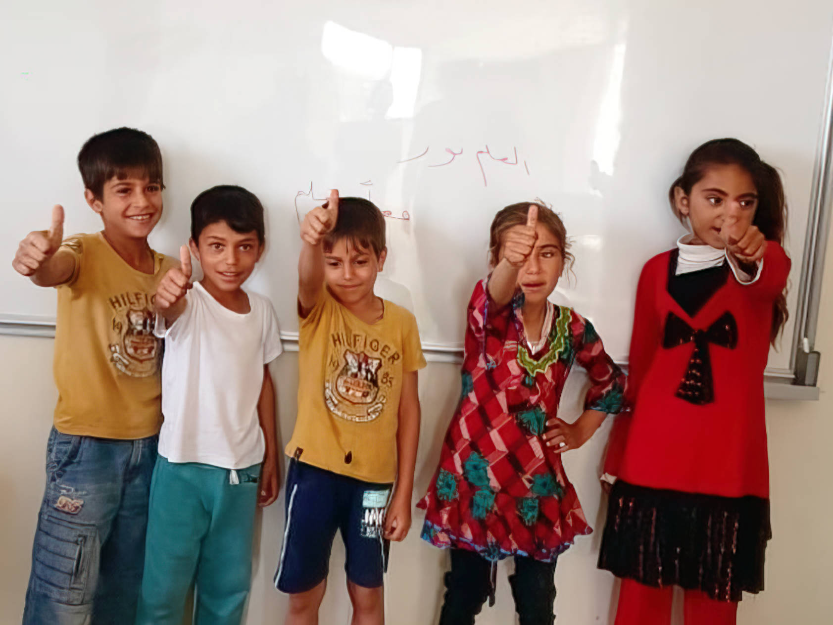5 Kinder im Grundschulalter vor Whiteboard