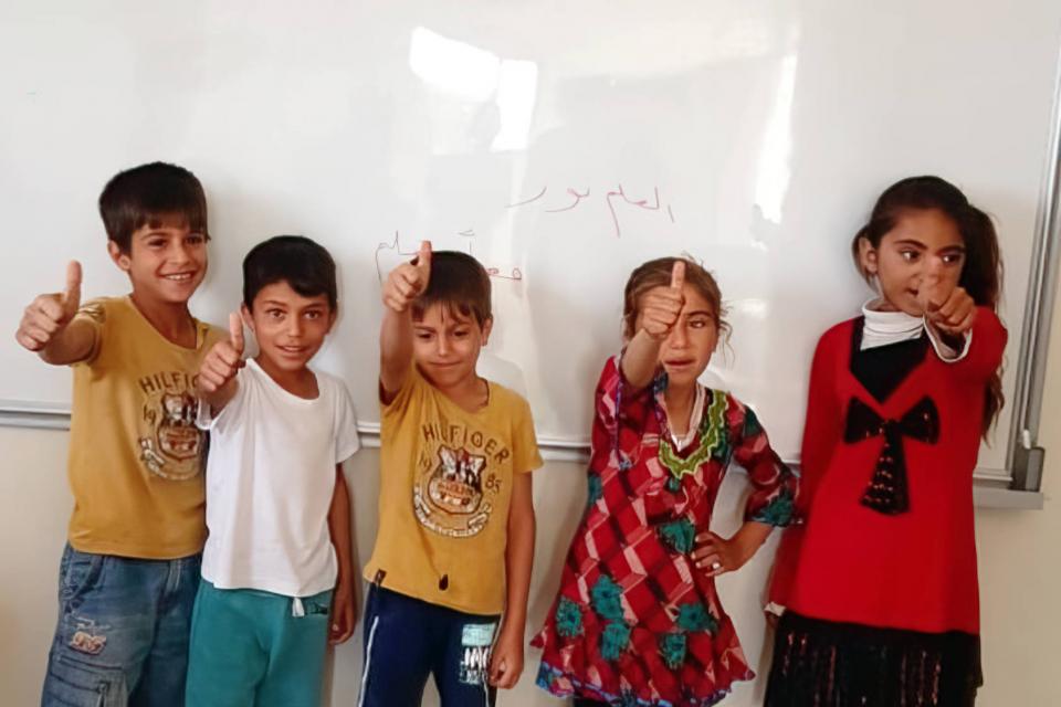 5 Kinder im Grundschulalter vor Whiteboard
